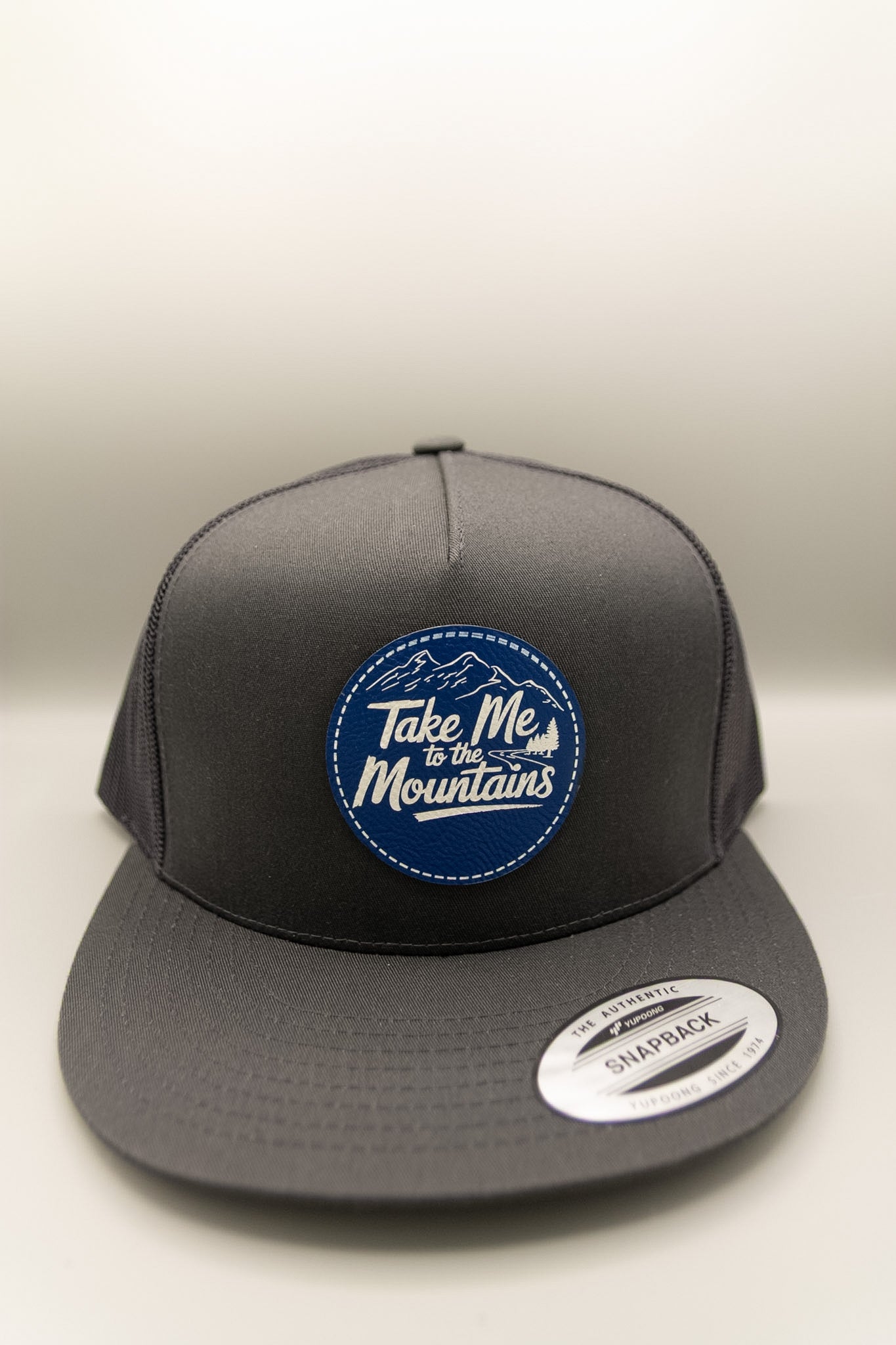 Take Me to the Mountains Blue White Patch Charcoal Flat Trucker Cap
