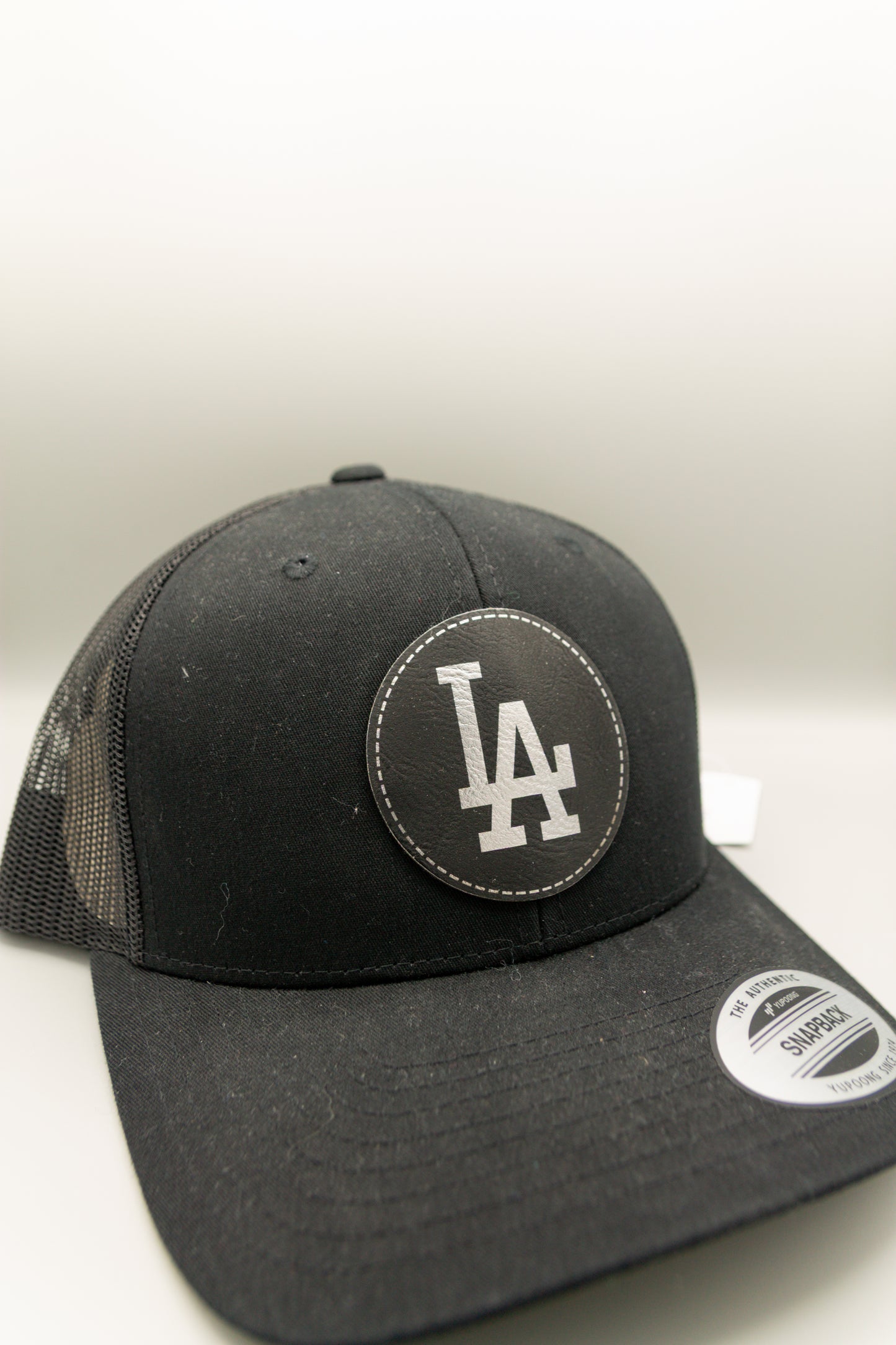 LA Black Silver Patch Black Curve Trucker Cap