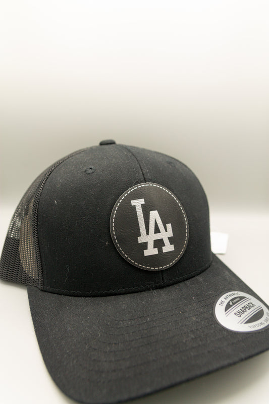 LA Black Silver Patch Black Curve Trucker Cap