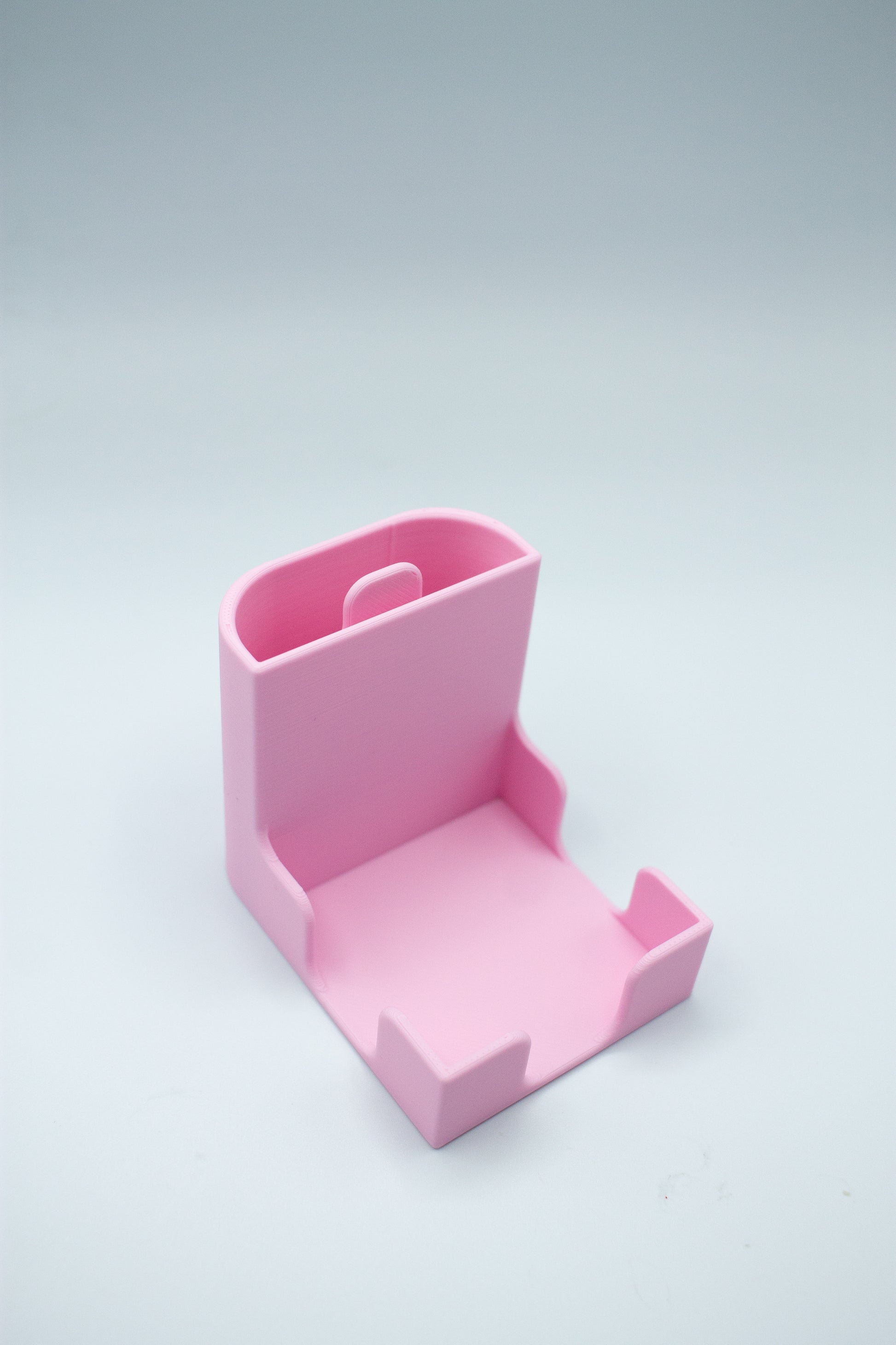 Pink post-it holder on a light gray background