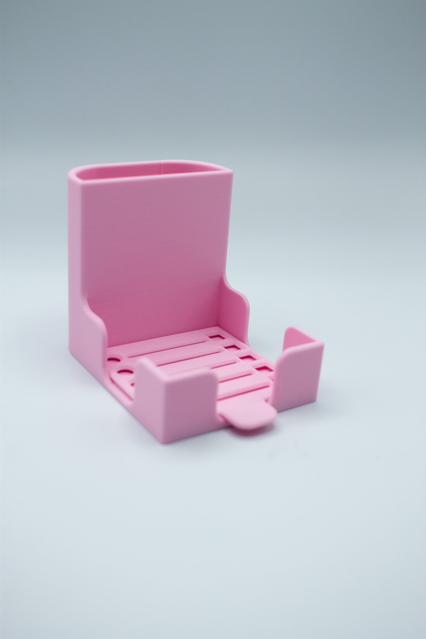 Pink post-it holder with to-do list stencil on a light gray background
