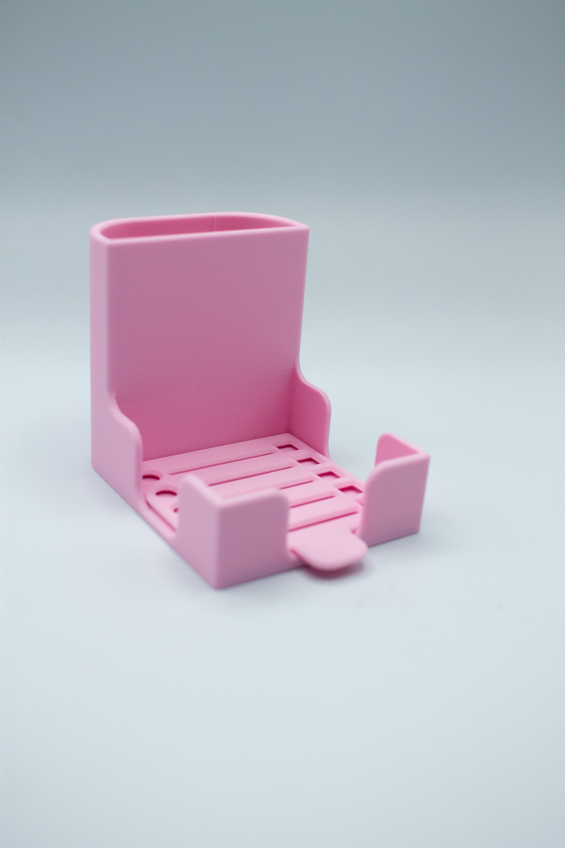 Pink post-it holder with to-do list stencil on a light gray background
