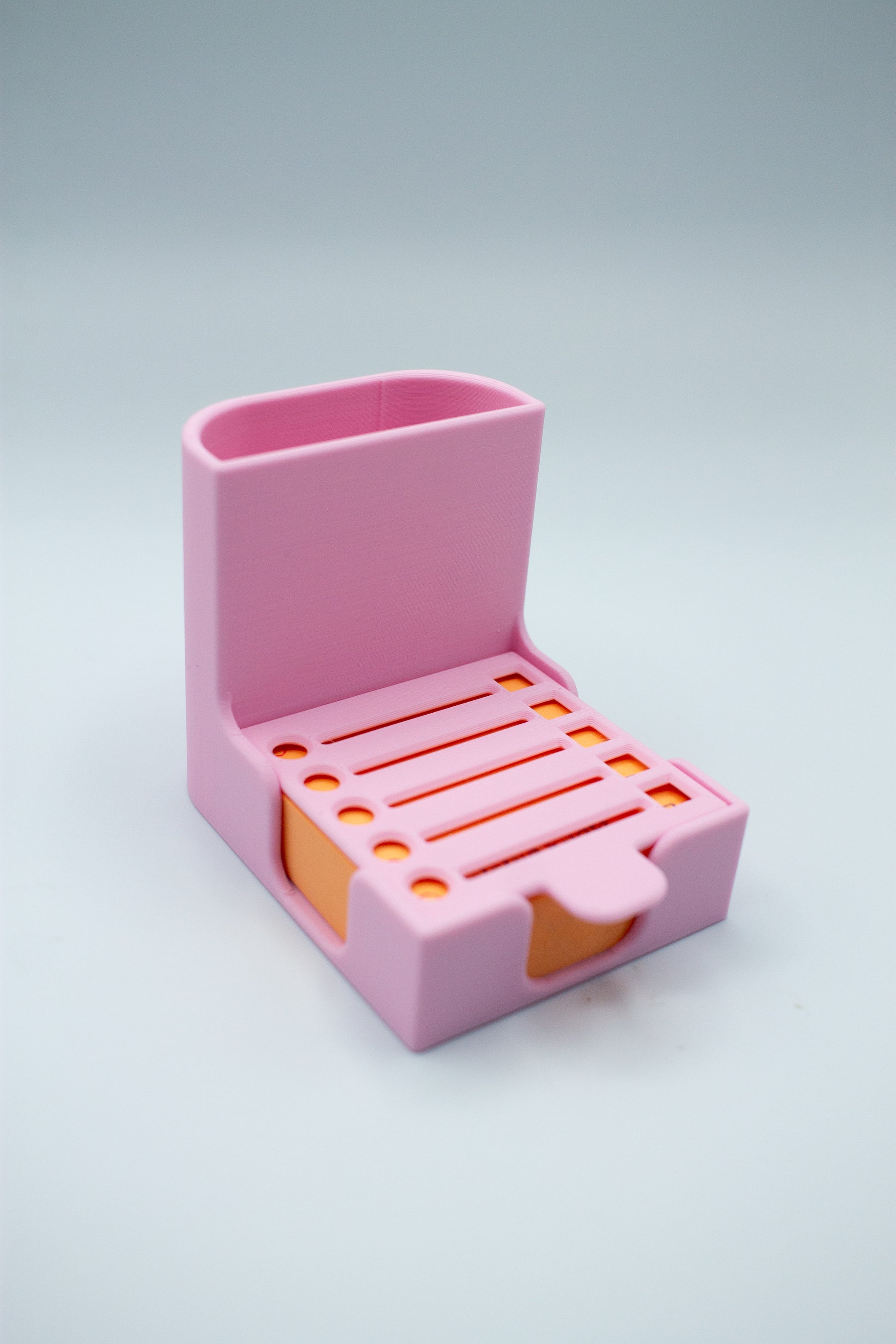 Pink post-it holder with to-do list stencil on a light gray background