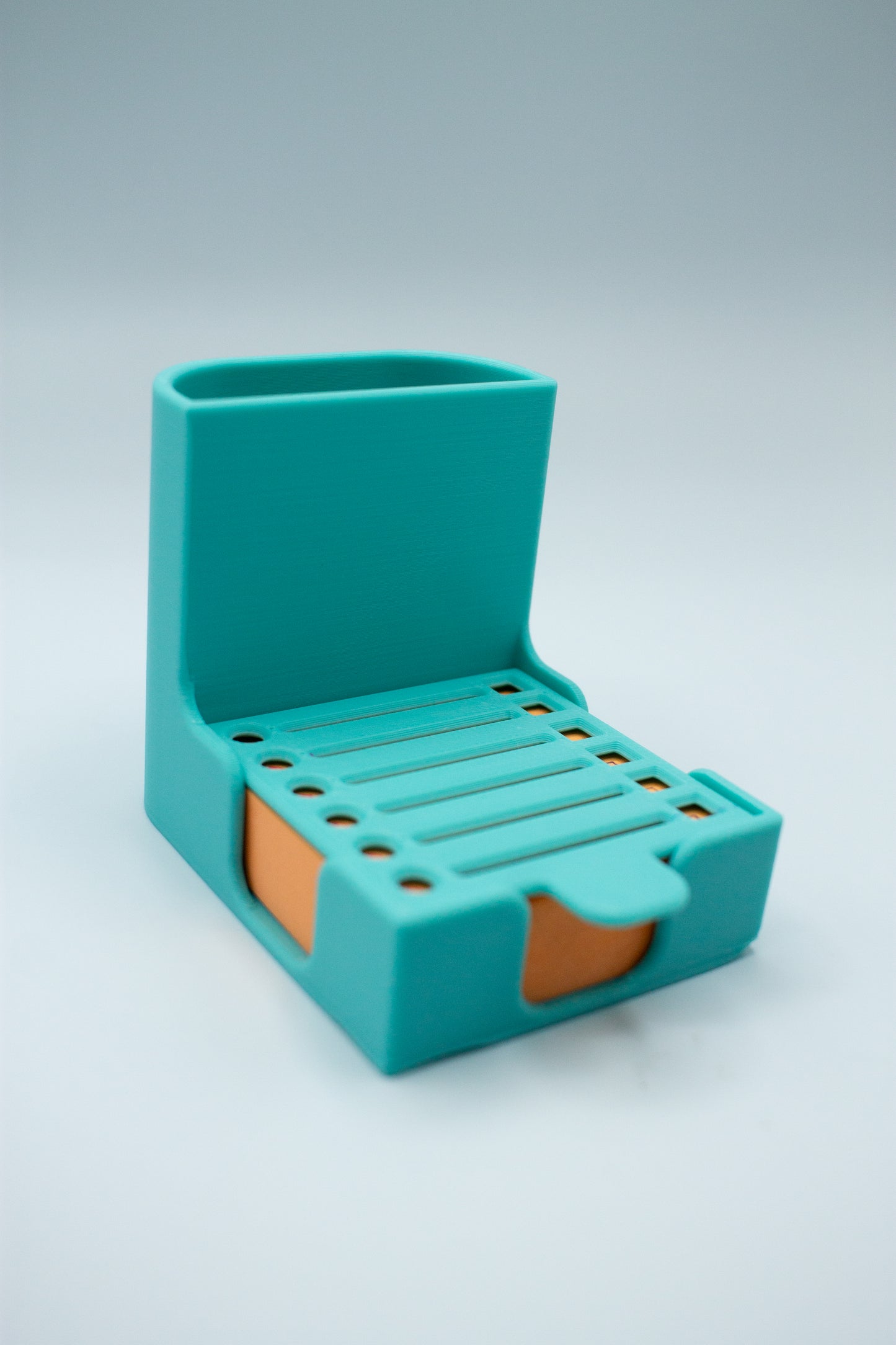 Turquoise teal post-it holder with to-do list stencil on a light gray background