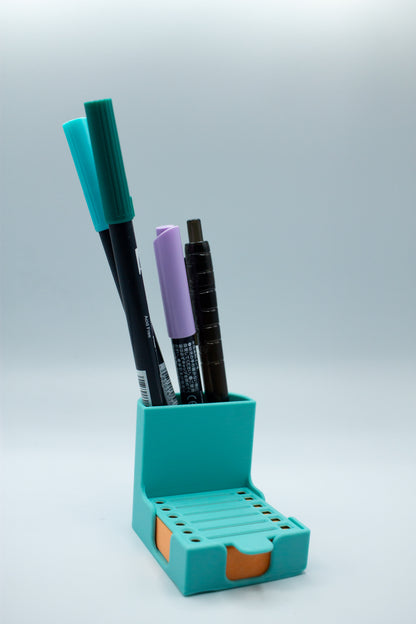 Turquoise pen holder with markers on a light gray background